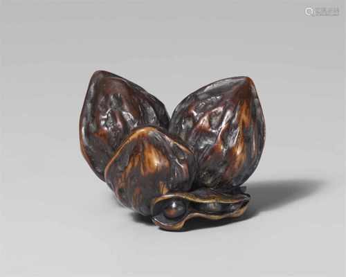 A large stained wood netsuke of three walnuts and two soy beans, by Unkoku. Late 19th centuryThree