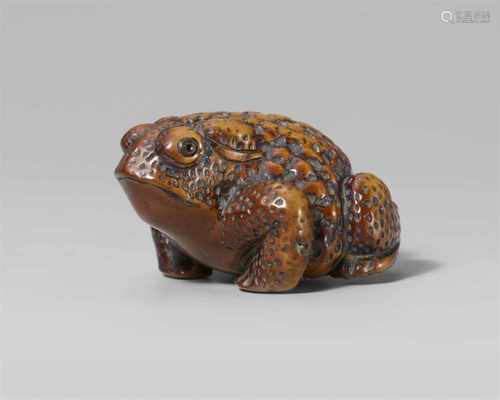 A boxwood netsuke of a toad. Mid-19th centurySquatting in typical pose with head turned slightly