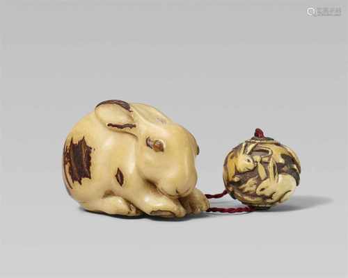 An unusual corozo nut netsuke of a crouching rabbit. 19th centuryWith head lowered and licking its