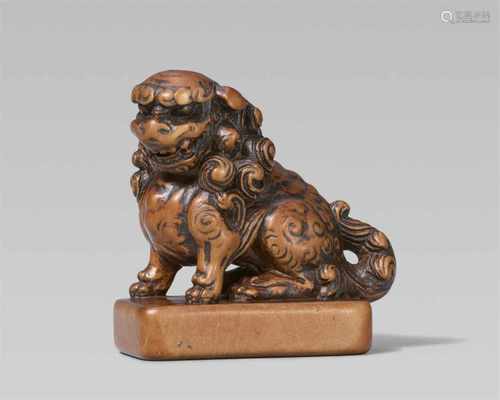 A large wood seal-type netsuke of a shishi. 19th centurySeated with a curly mane and tail on a