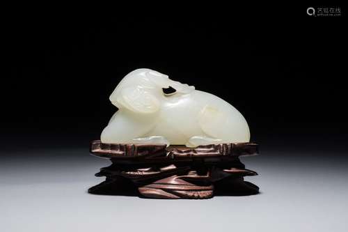 A Chinese jade carving of a ram on wooden base, 19th C.