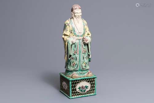 A large Chinese verte biscuit figure of an immortal on reticulated stand, Kangxi