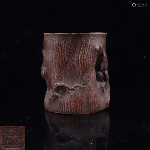 A TREE STUMP SHAPED BRUSH POT