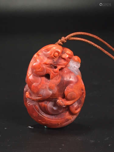 AN OLD RED AGATE CARVED BEAST SHAPED PENDANT