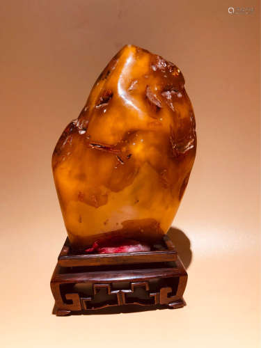 AN AMBER CARVED MOUNTAIN SHAPED PENDANT