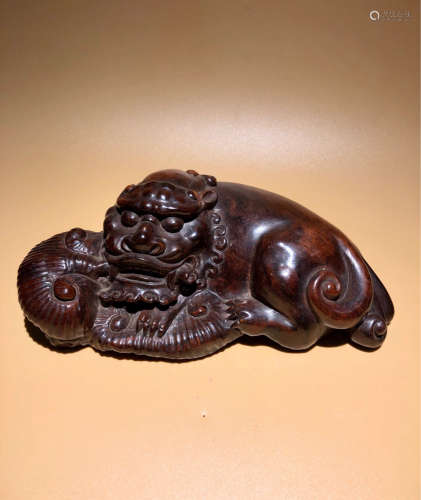 A RED WOOD CARVED BEAST PENDANT