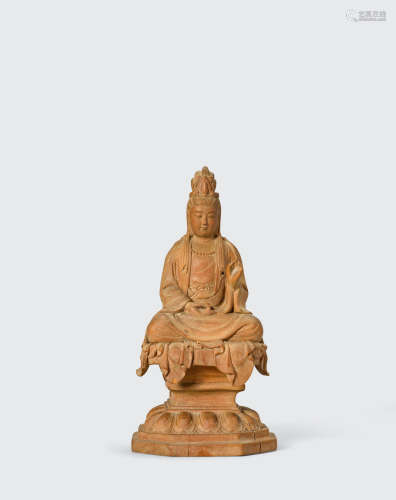 A carved wood figure of a seated bodhisattva
