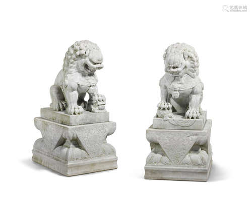 A pair of massive marble fu lions on pedastals