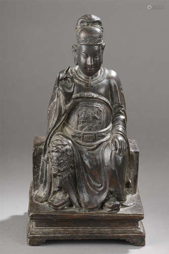 Dignitaire assis sur un trône vêtu d'une longue tunique couvrant une cuirasse et coiffé d'un bonnet  lié à son rang. Bronze. Chine. Dynastie Ming. 1368 à 1644. 35cm. Usure au socle.