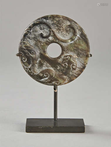 Disque Bi archaïsant ciselé d'un dragon lové. Jadéite calcifié. Chine. Diam 6 cm -