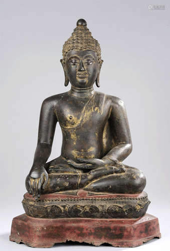 Buddha Maravijaya assis en vajrasana   sur un socle lotiforme à base   hexagonale vêtu d'une simple robe monastique   utarasanga lui couvrant l'épaule gauche un pan court   rabattu en hauteur, la main gauche en offrande dhyanamudra et la droite en   prise de la terre à témoin   bumishparshamudra. Son visage exprimant la sérénité par de lourdes paupières les yeux mi-clos préconisant le regard   à l'intérieur de soi. La coiffure   organisée en fines bouclettes spiralées est surmontée de la protubérance crânienne Ushnisha. Bronze à patine   brune,  traces de dorure et de   polychromie. Thaïlande. Royaume de Chien Seng.14 ème   siècle.  57cm .   Usures et manques à la base du socle.