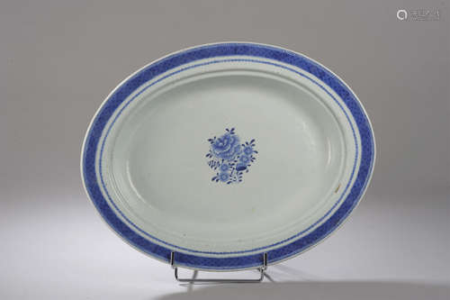 Plat en porcelaine de la Compagnie des Indes décoré en   bleu cobalt sous couverte d'un bouquet fleuri et d'un liseré au marli. Chine. Dynastie Qing. 18 ème siècle.  Egrenures. 42,5x33cm.