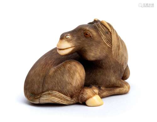 AN HORN INLAID IVORY NETSUKE OF A RECUMBENT HORSE ...