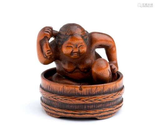 A WOOD NETSUKE OF A WOMAN BATHING IN A TUB second ...