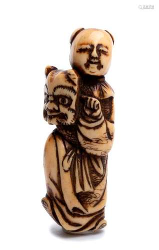 A STAG ANTLER NETSUKE OF A KARAKO WITH ONI MASK 19...