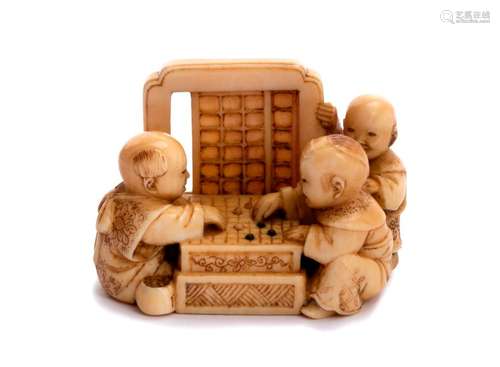 AN IVORY NETSUKE OF THREE CHILDREN PLAYING GŌ 19th...