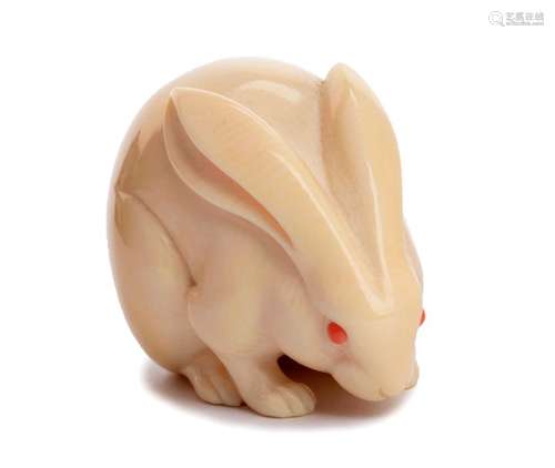 A CORAL INLAID IVORY NETSUKE OF A RABBIT 20th cent...