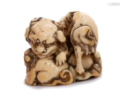 AN IVORY NETSUKE OF A SHISHI WITH TWO CUBS second ...