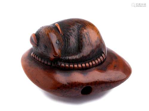 A HORN INLAID WOOD NETSUKE OF A MOUSE ON A CHESTNU...