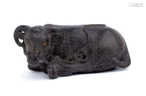 A WOOD NETSUKE OF A RECUMBENT OX Kyoto, second qua...