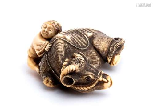 AN IVORY NETSUKE OF A RECUMBENT OX WITH CHILD Kyot...