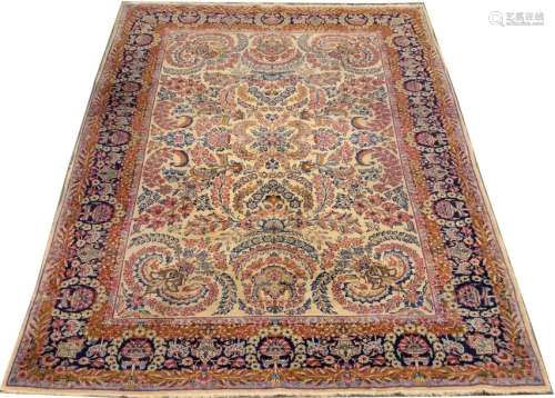 Tapis Kirman. Le fond, crème, présente de nombreus...