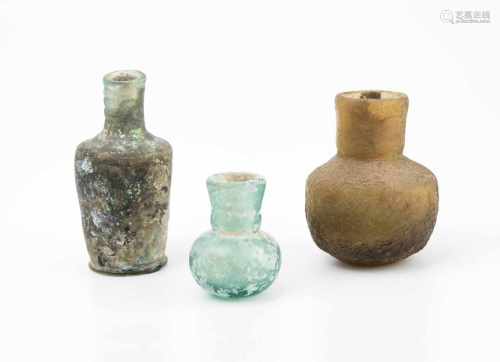 Lot: Drei FläschchenSpätantik und islamisch. Glas. Eine dickwandige, olivfarbene kleine Flasche