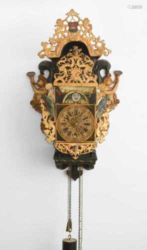 StooluhrHolland, um 1800. Auf bemaltem, mit Schnitzereien versehenen Holzträger stehende Uhr mit