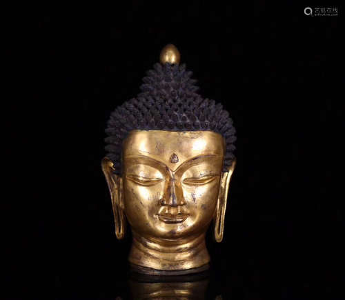 A GILT BRONZE MOLDED SHAKYAMUNI HEAD STATUE