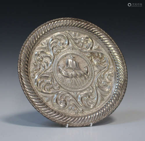 A Continental .800 silver circular dish, decorated in relief with a Viking boat within scrolls,