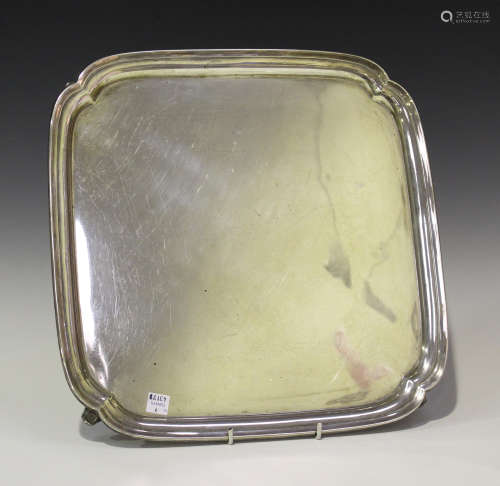 A George V silver salver of lobed square form, raised on scroll feet, Birmingham 1931 by Oldfields