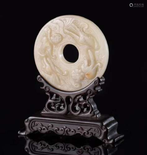 A RING-SHAPED HETIAN JADE ORNAMENT WITH BASE