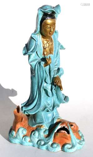 A Chinese porcelain figure of Guanyin standing on the back of a water dragon, 37cms (14.5ins) high.