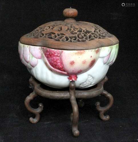 A Chinese famille rose fruit form box with pierced and carved hardwood cover, standing on a hardwood