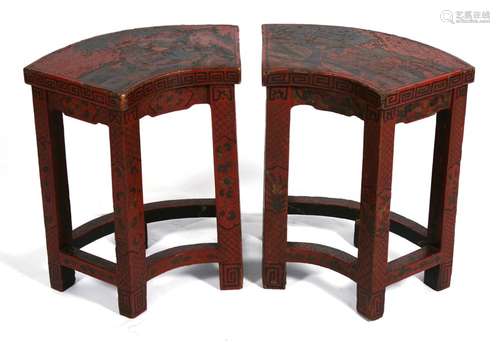 A pair of Chinese red lacquered fan shaped stools decorated with figures in a landscape, 43cms (