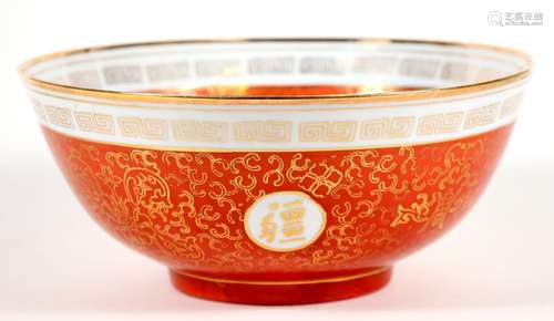 A Chinese bowl decorated with gilded characters and foliate scrolls, on a red ground, 26cms (10.