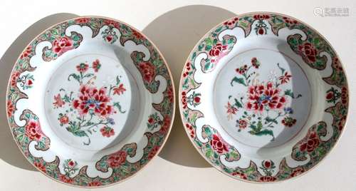 A pair of early 18th century famille rose plates decorated with peonies, 23cms (9ins) diameter.