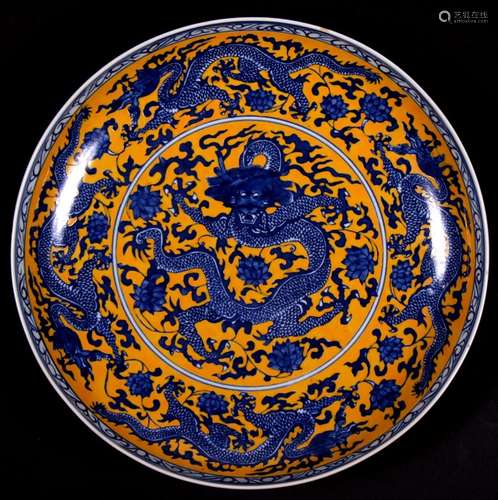 A large Chinese shallow bowl decorated with dragons on a yellow ground, blue seal mark to underside,