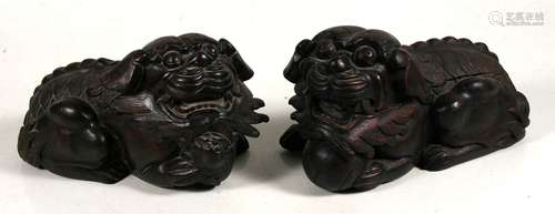 A pair of Chinese carved wood Buddhistic lions, 32cms(12.5ins) long.