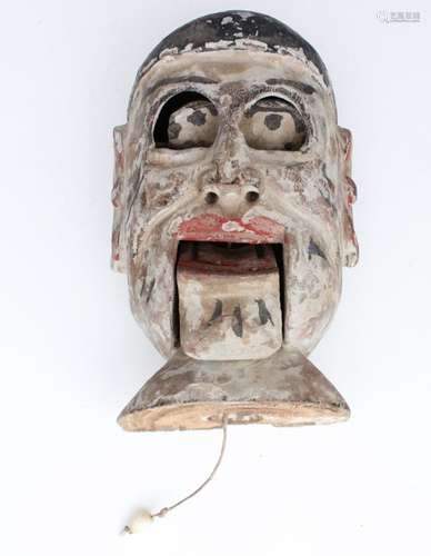 A 19th century Chinese carved painted wooden puppet head with pull-string mouth, 15cms (6ins) high.