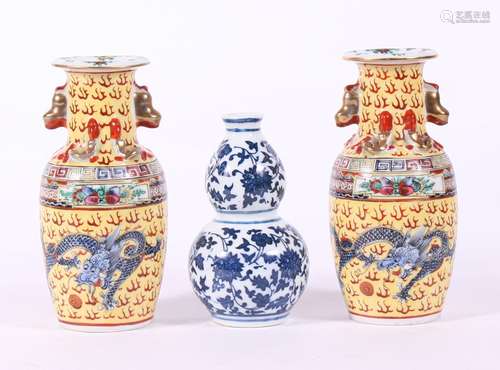 A pair of Chinese vases decorated with dragons on a yellow ground, 6cms (6.25ins) high; together