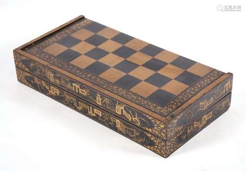 A late 19th century Chinese lacquered games box decorated with gilded buildings on a black ground,