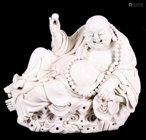 A Chinese blanc de chine style figure depicting a seated Buddha wearing a large bead necklace, 29cms