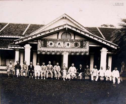 An early 20th century Lee Yoong black & white photograph depicting sixteen gentlemen sat outside a