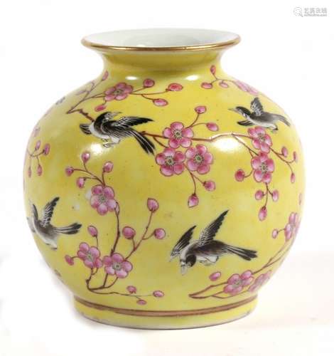 A Chinese vase decorated with birds and prunus on a yellow ground, red four-character mark to