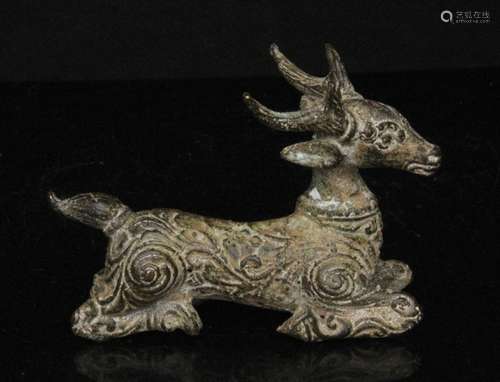 An Eastern / Asian patinated metal model of a recumbent deer, 8cms (3.1ins) long.