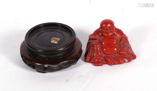 An early 20th century Chinese cinnabar lacquer figure of a seated Buddha, 5cms (2ins) high; together