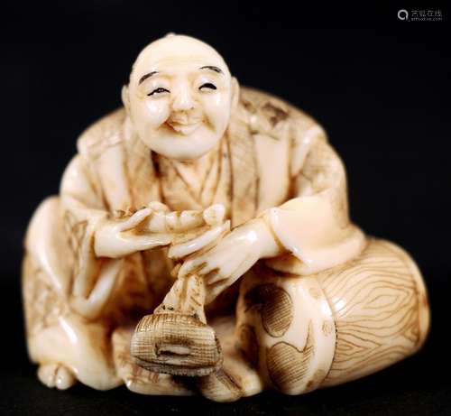 A Japanese carved ivory netsuke in the form of a man with a pipe and tobacco pouch, signed '