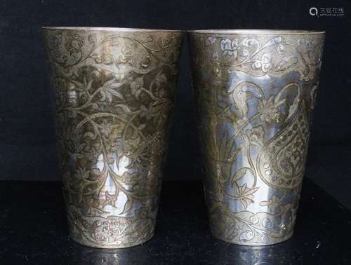 Two Islamic / Persian engraved beakers of tapering form, decorated with foliate scrolls, 14.5cms (