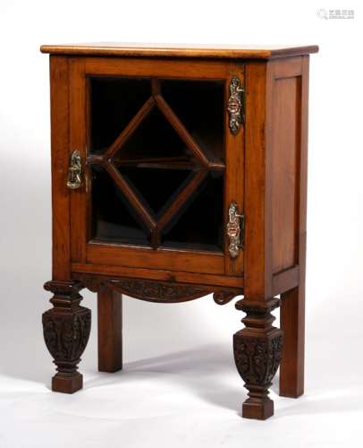 A small walnut & oak display cabinet, the single glazed door enclosing a shelved interior, on carved